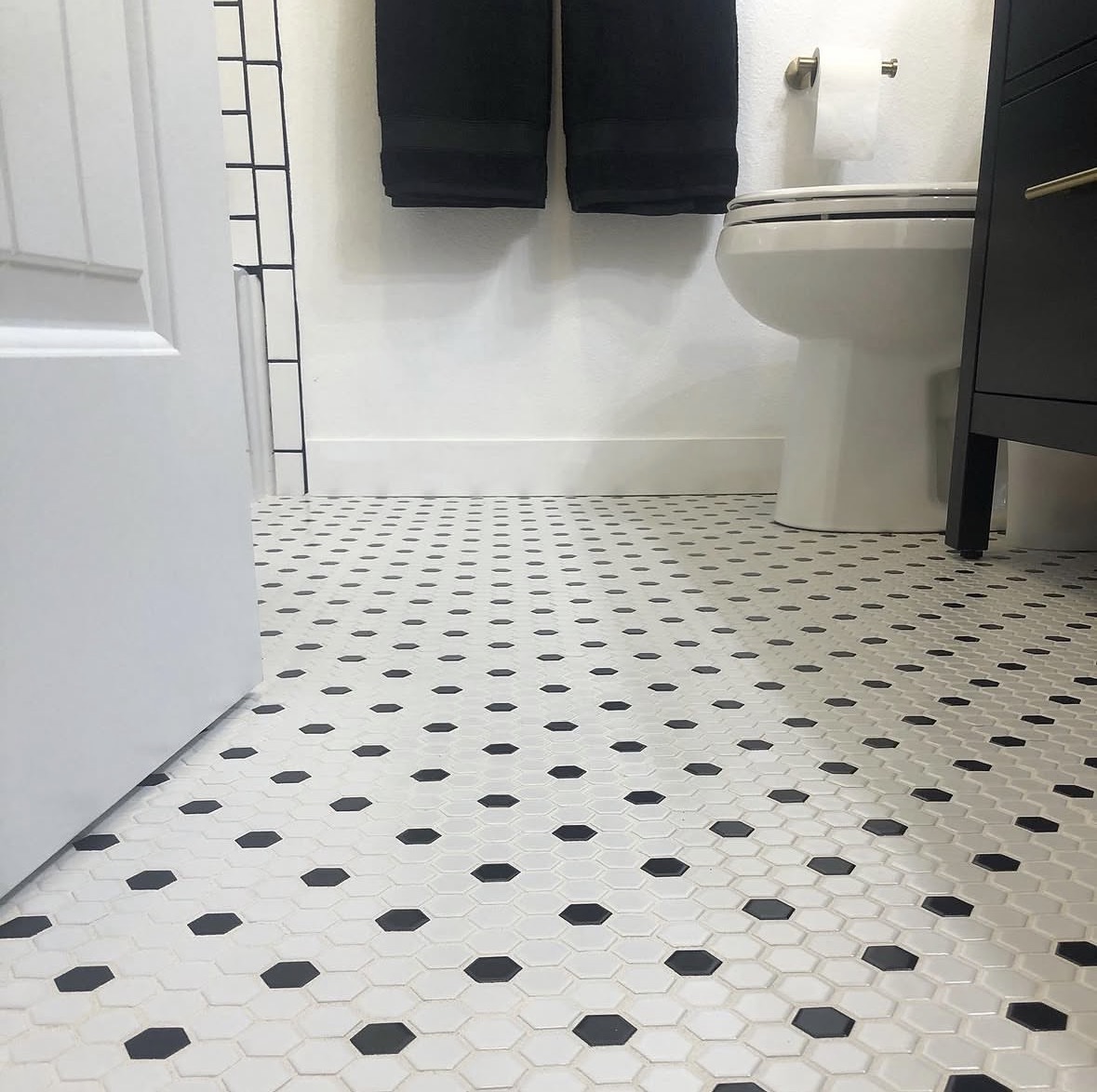 Classic hex-tile floor — Black-and-white mosaic laid tight, satin-black accents